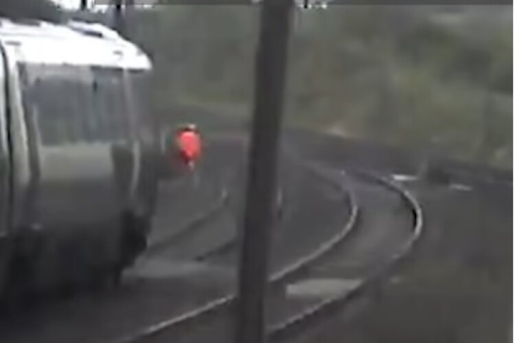 The moment a track worker was nearly hit by a speeding train was captured on the CCTV of another passign train