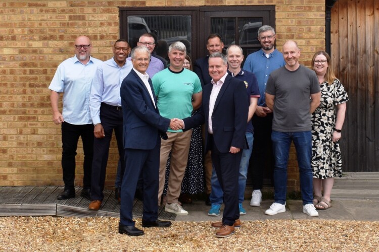 Malcolm Thornton and Scott Wilson shake hands with the Pudlo team behind them